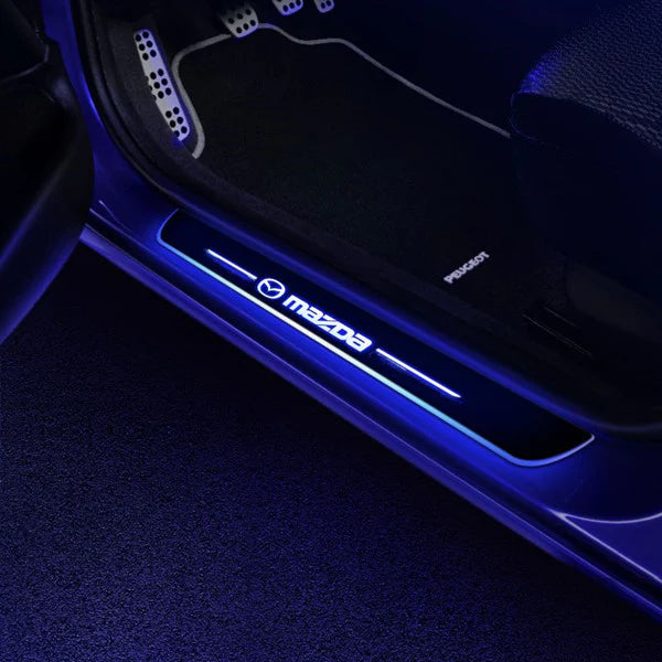 Car door sill with Mazda logo illuminated by blue light